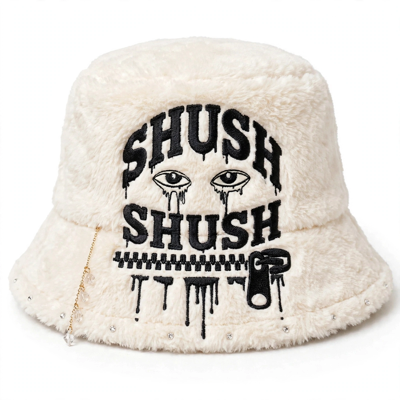 Cream faux-fur SHUSH bucket hat with a black stacked SHUSH logo, clear crystal gem dangle and small gems along the front brim