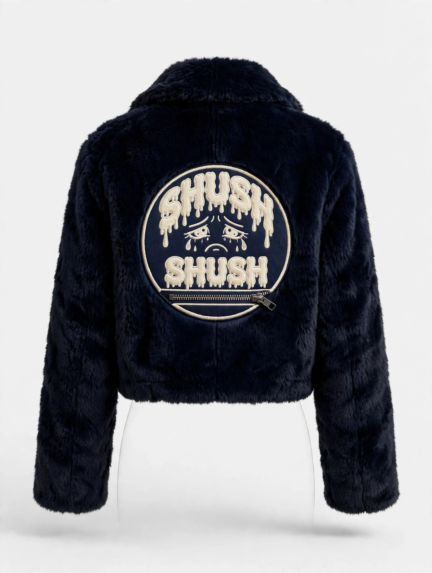 Blood, Sweat and Tears fur coat in Navy — the back carries the circular emblem in cream thread: SHUSH in dripping letters over crying eyes, SHUSH again, and a zipper mouth