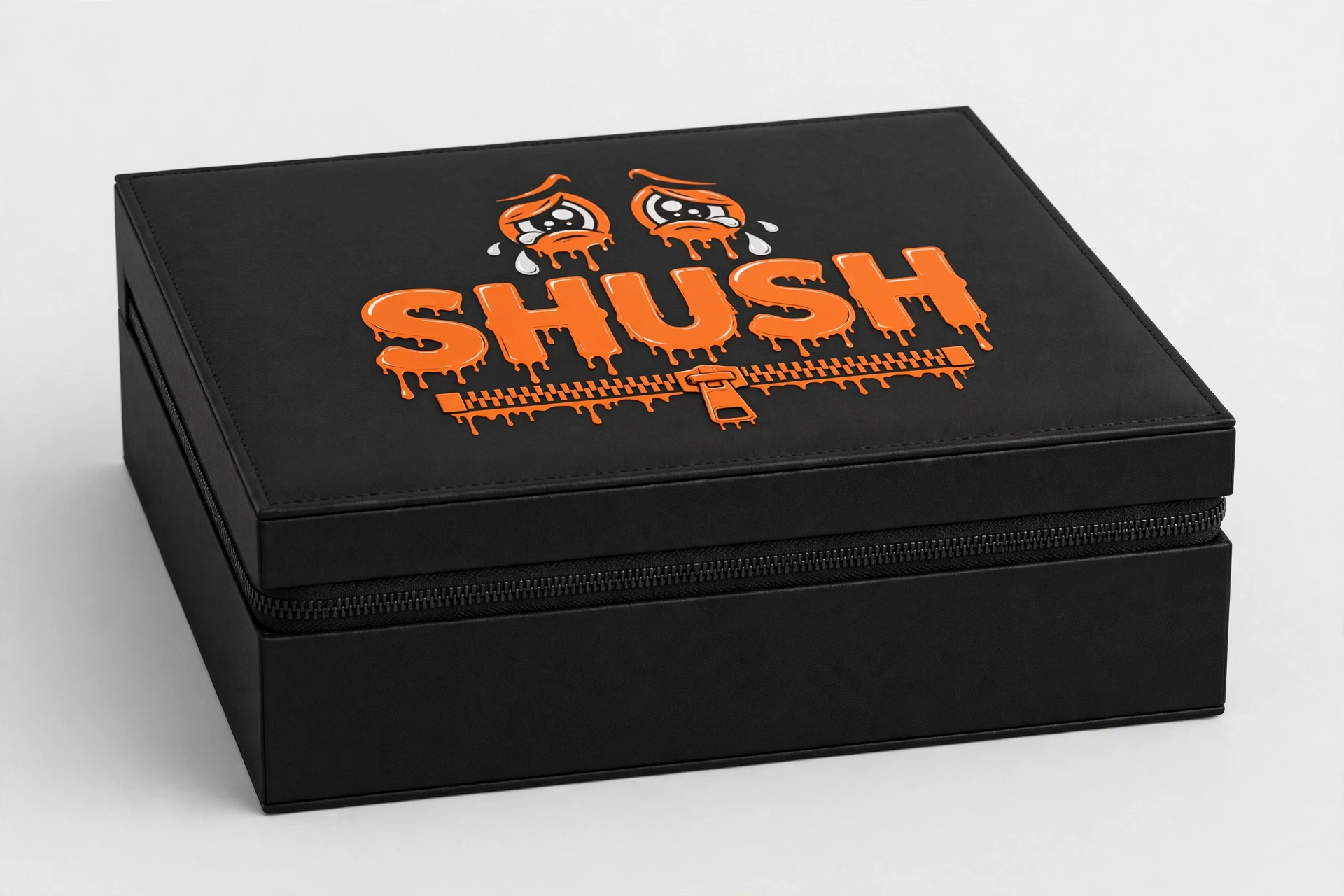 The matte black zippered SHUSH keepsake case, closed, with the orange dripping logo and crying eyes on the lid