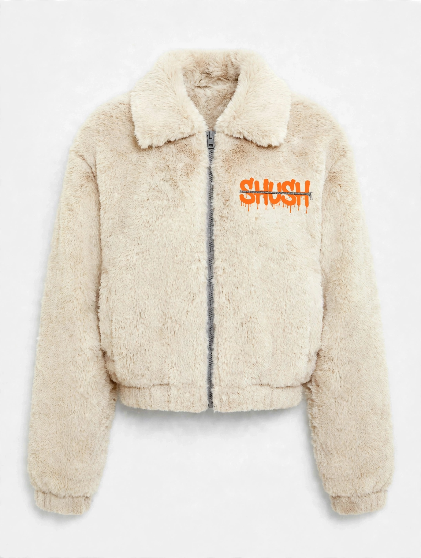 Women's cropped cream faux-fur jacket, front view — plush fur, zip front, and a small embroidered SHUSH mark at the left shoulder: the word SHUSH in orange dripping letters zipped shut by a silver zipper