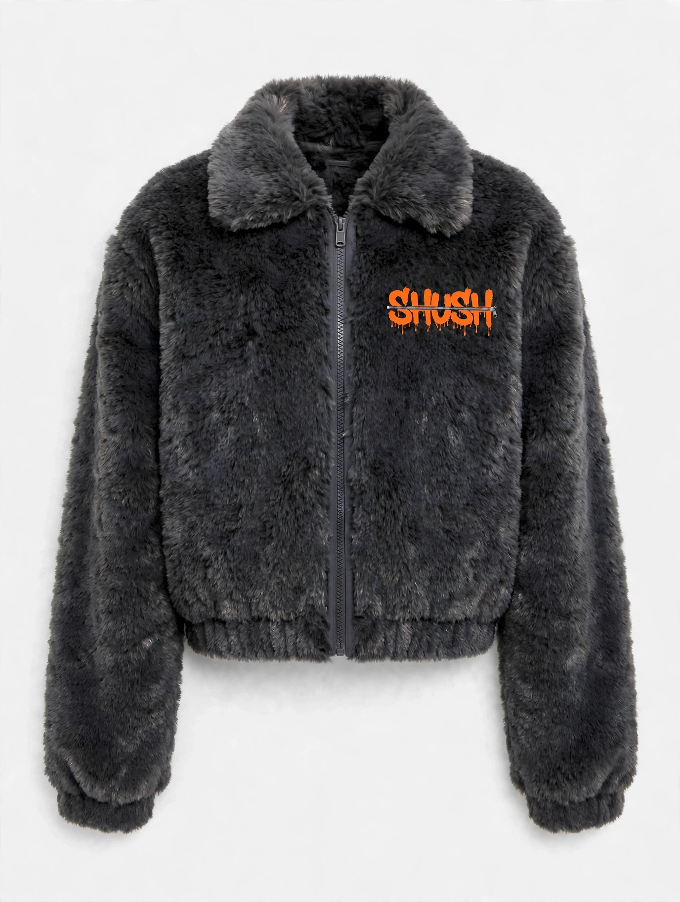 Women\u2019s cropped dark charcoal gray faux-fur jacket, front view — plush fur, zip front, and a small embroidered SHUSH mark at the left shoulder: the word SHUSH in orange dripping letters zipped shut by a silver zipper